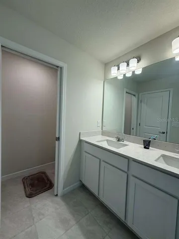 a spacious bathroom with a granite countertop sink and a mirror