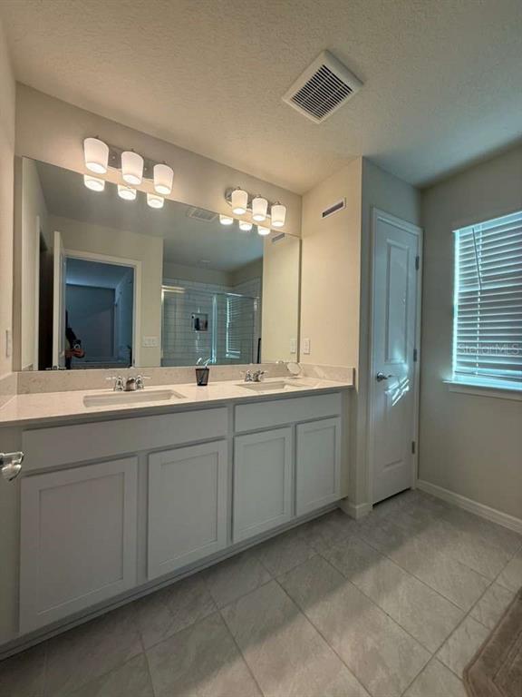 2579 Winsome Way Davenport, FL 33896 - Photo 19 of 25 a spacious bathroom with a granite countertop sink and a mirror