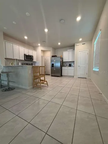 a view of a kitchen with kitchen island a counter top space appliances and cabinets