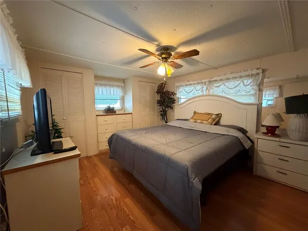 a bedroom with a large bed and a flat tv screen on dresser