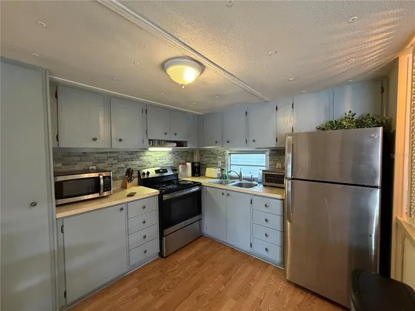 a kitchen with white cabinets and white appliances