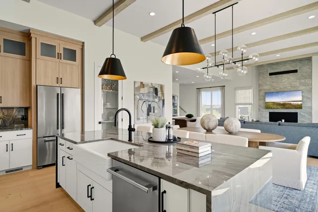 a kitchen with stainless steel appliances granite countertop a stove a kitchen island a dining table and chairs