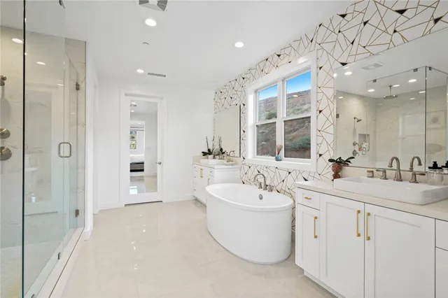 a bathroom with a double vanity sink mirror and bathtub