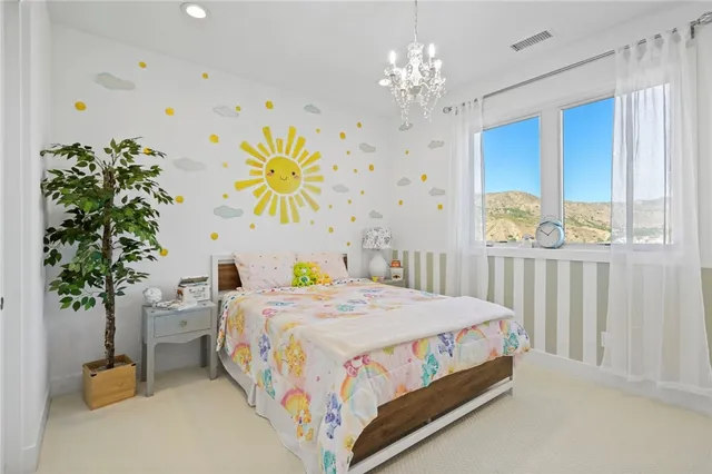 a bedroom with a bed table and a chandelier