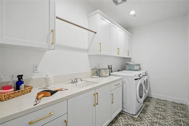 a utility room with sink dryer and washer
