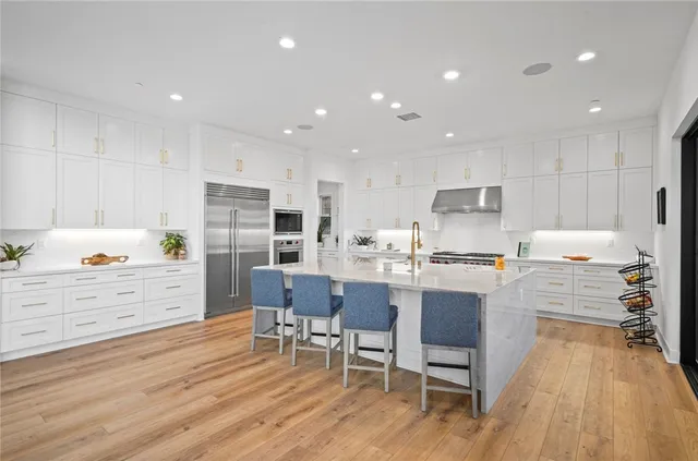 a kitchen with a table chairs wooden floors and view living room