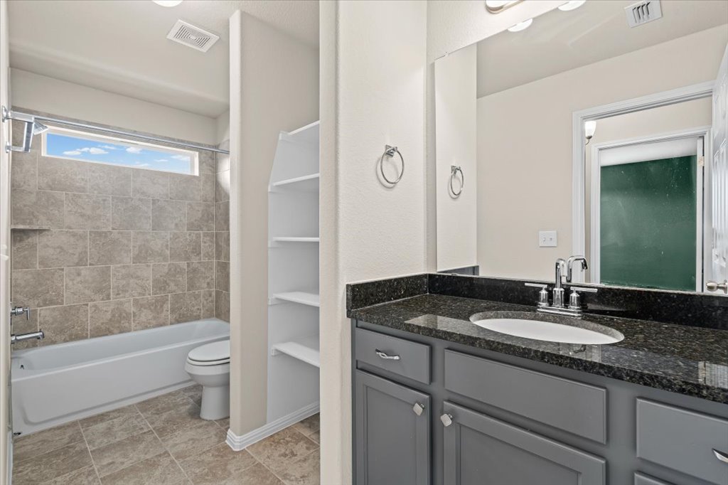 6313 Mary Lewis Drive Austin, TX 78747 - Photo 14 of 20 a bathroom with a granite countertop sink a toilet and bathtub