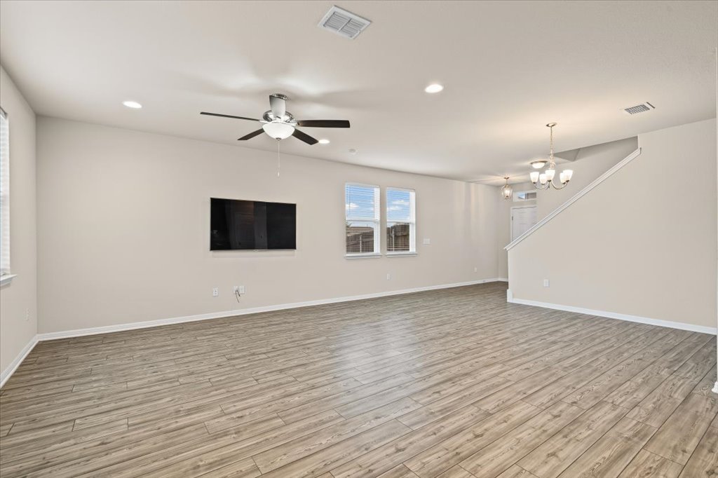 6313 Mary Lewis Drive Austin, TX 78747 - Photo 3 of 20 a view of an empty room with wooden floor and a ceiling fan