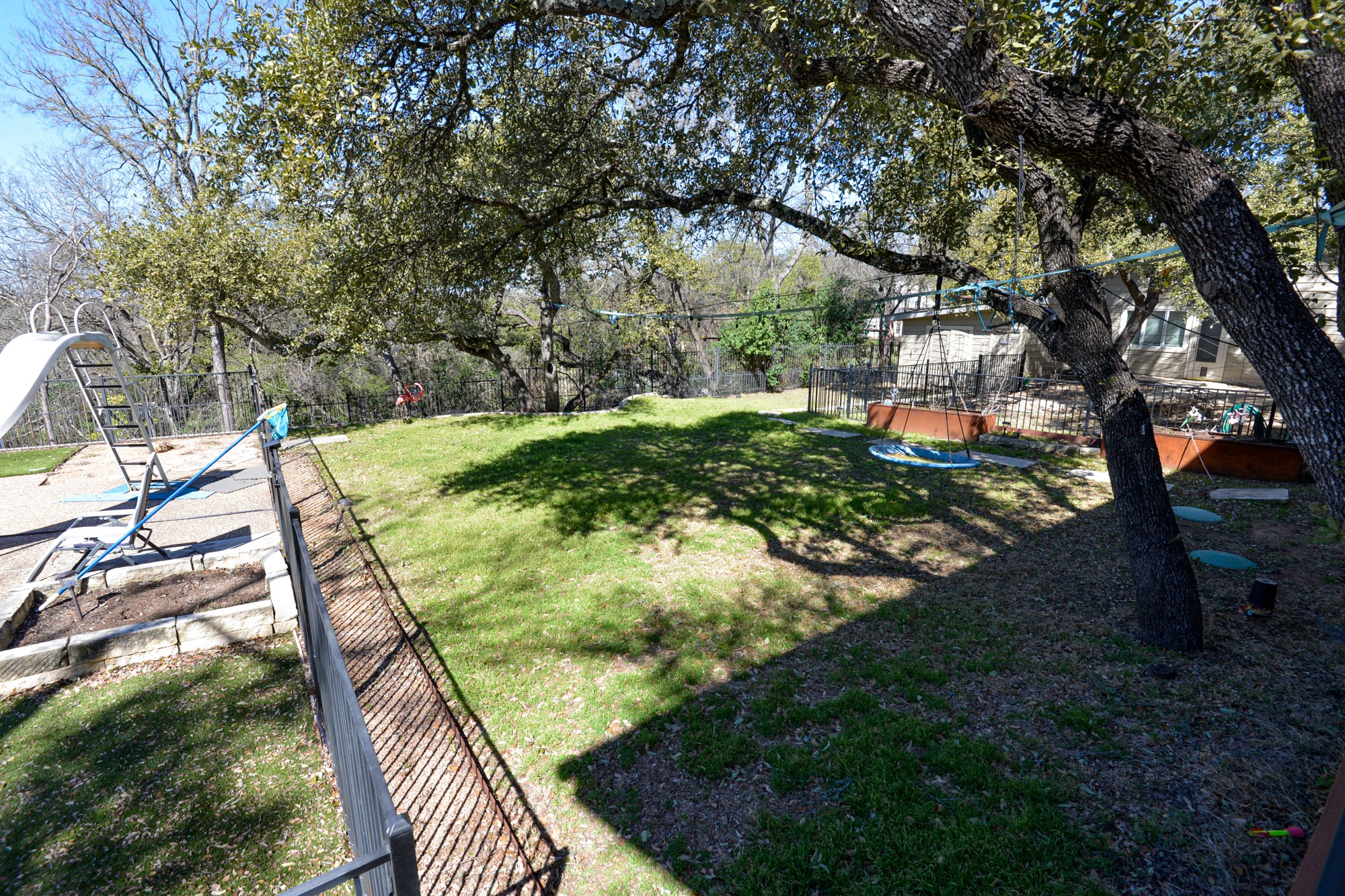 10710 D-K Ranch Road Austin, TX 78759 - Photo 3 of 34 A tiered backyard with mature trees provides shaded recreation.