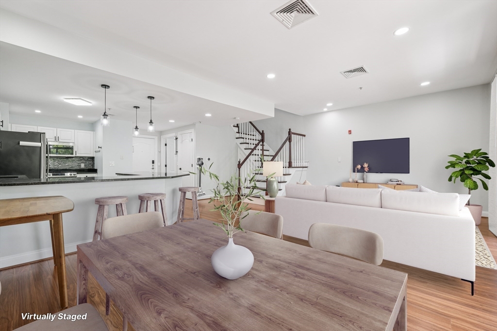 614 Pond Street, Unit 2104 Braintree, MA 02184 - Photo 2 of 29 a living room with furniture and a flat screen tv