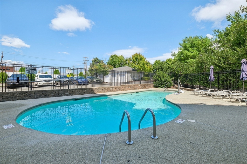 614 Pond Street, Unit 2104 Braintree, MA 02184 - Photo 24 of 29 a view of a swimming pool with a lawn chairs