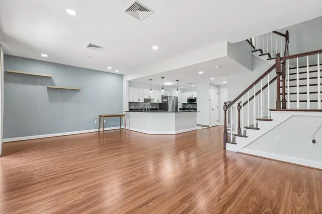 a view of empty room with wooden floor