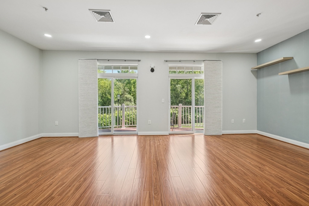614 Pond Street, Unit 2104 Braintree, MA 02184 - Photo 4 of 29 a view of an empty room with wooden floor and a window
