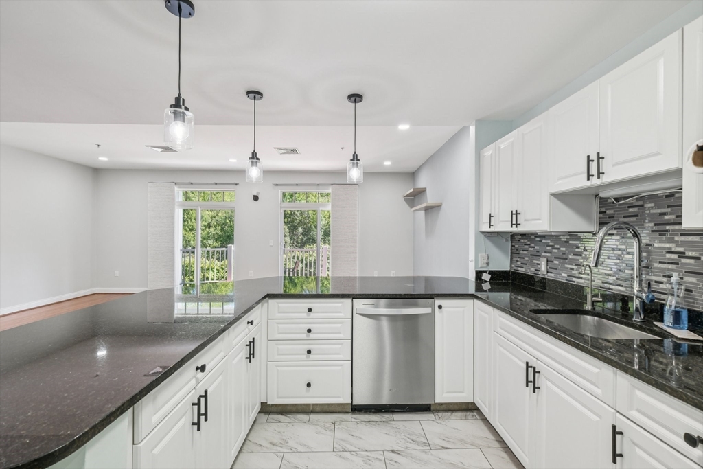 614 Pond Street, Unit 2104 Braintree, MA 02184 - Photo 8 of 29 a kitchen with granite countertop a sink stainless steel appliances white cabinets and a granite counter tops