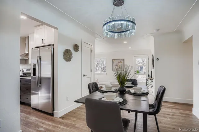 a view of a dining room with furniture a chandelier and wooden floor