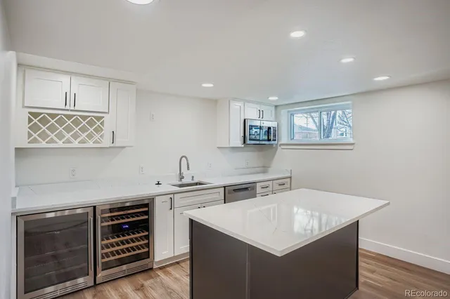 a kitchen that has a sink a stove and cabinets