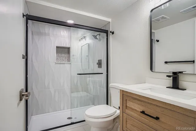 a bathroom with a shower curtain a sink and a toilet