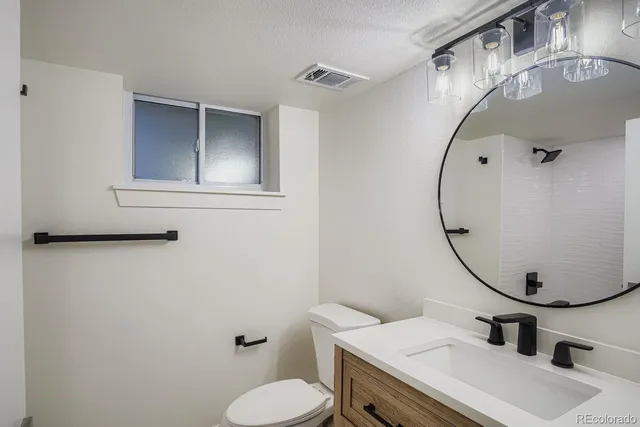 a bathroom with a sink mirror and toilet