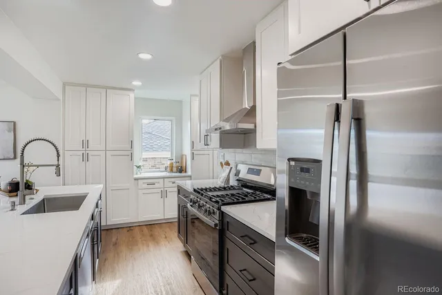 a kitchen with stainless steel appliances granite countertop a sink stove and refrigerator