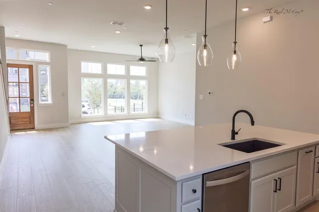 a kitchen with stainless steel appliances granite countertop a sink a window and a counter space