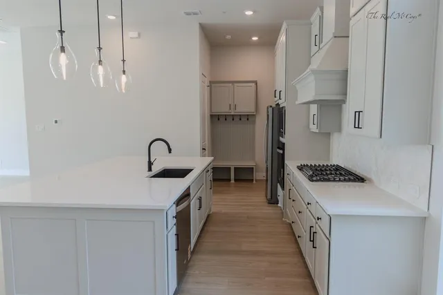 a kitchen with stainless steel appliances granite countertop a sink stove and refrigerator