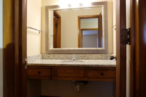 a bathroom with a granite countertop sink and a mirror