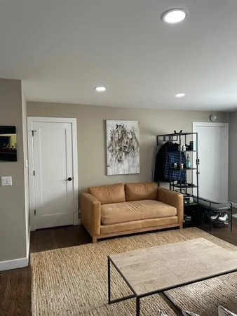 a living room with furniture a rug and a window