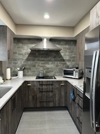 a kitchen with a sink stainless steel appliances wooden floor and cabinets
