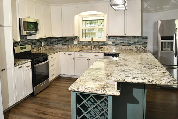 a kitchen with granite countertop a sink and a stove