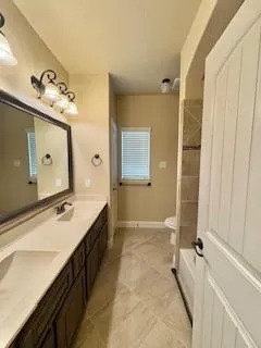 a bathroom with a double vanity sink a mirror and a bathtub