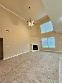 an empty room with windows and ceiling fan