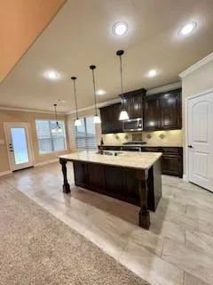 a large kitchen with a large counter top space appliances and cabinets