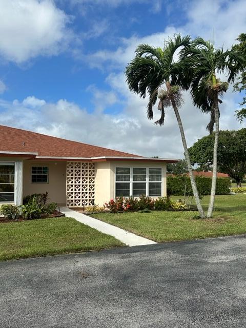 4585 Northwest 3rd Street, Unit D Delray Beach, FL 33445 - Photo 1 of 42 a front view of a house with a garden and trees