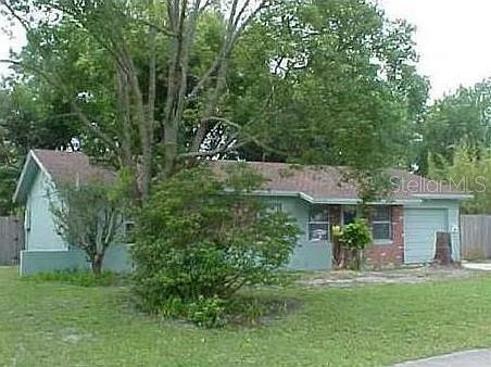 a view of a house with a yard and potted plants