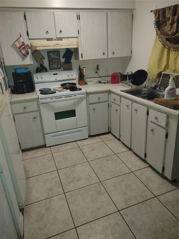 7798 Toledo Street Orlando, FL 32822 - Photo 5 of 12 a kitchen with a stove sink and cabinets