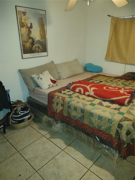 7798 Toledo Street Orlando, FL 32822 - Photo 7 of 12 a bedroom with a bed and a painting on the wall