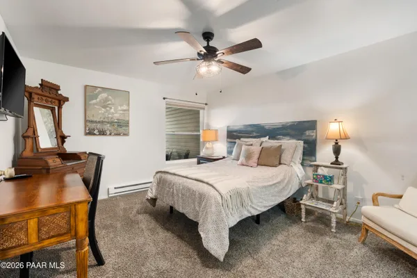 a bedroom with a bed a couch and a chandelier