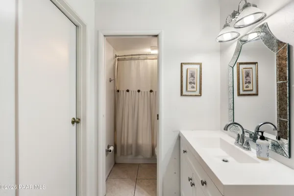 a bathroom with a double vanity sink a mirror and a shower