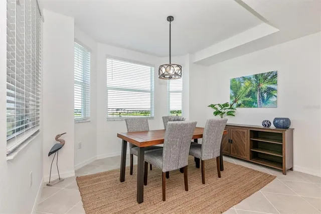 a kitchen with stainless steel appliances granite countertop a sink a stove a refrigerator and white cabinets with wooden floor