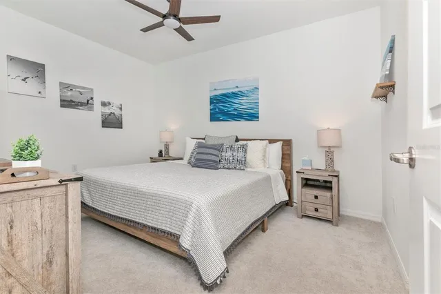 a bedroom with a bed and a lamp on dresser