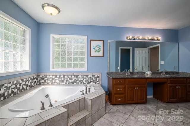 a bathroom with a bathtub sink and double vanity