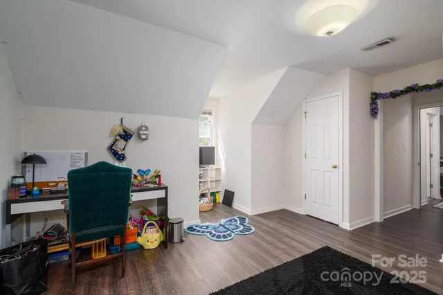 a bedroom with furniture and a wooden floor