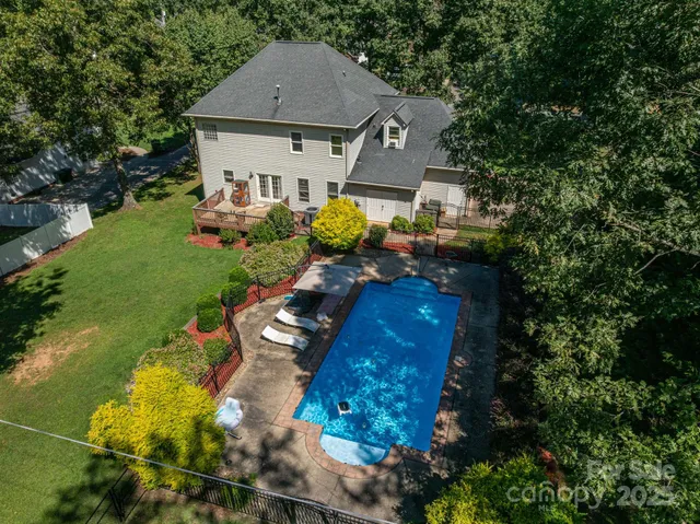 a aerial view of a house with swimming pool a yard and outdoor seating