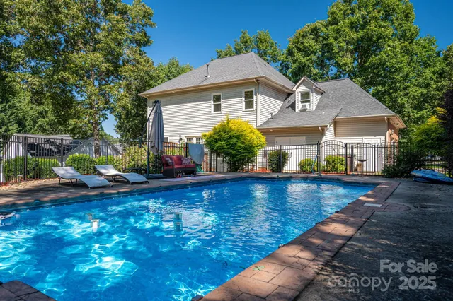 a view of a house with pool and sitting area