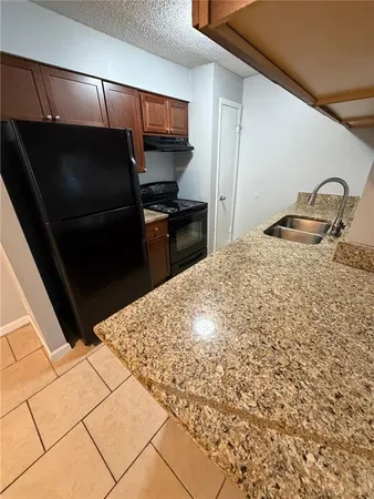 a kitchen with a refrigerator and a stove