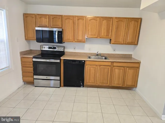 a kitchen with stainless steel appliances a stove a sink and a microwave