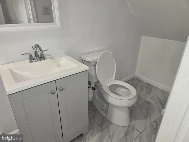 a white toilet sitting next to a bathroom sink