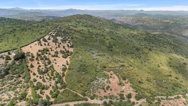a view of a field with mountains in the background
