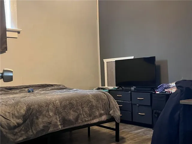 a bedroom with a bed and a flat screen tv