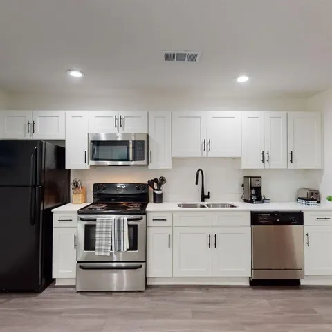 a kitchen with cabinets stainless steel appliances and sink